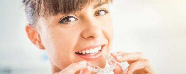 Dame hat Invisalign Zahnspange in der Hand