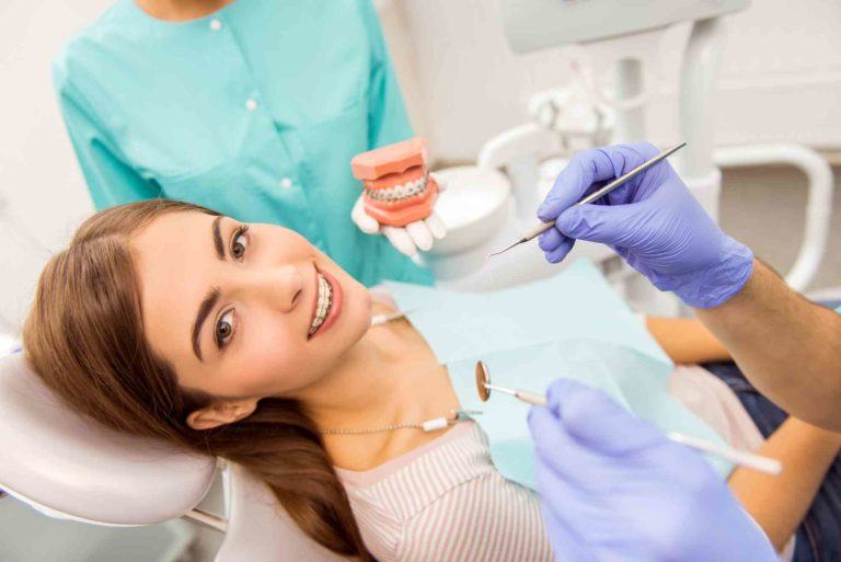 Patientin liegt im Zahnarztsessel Hand mit Hadachuh